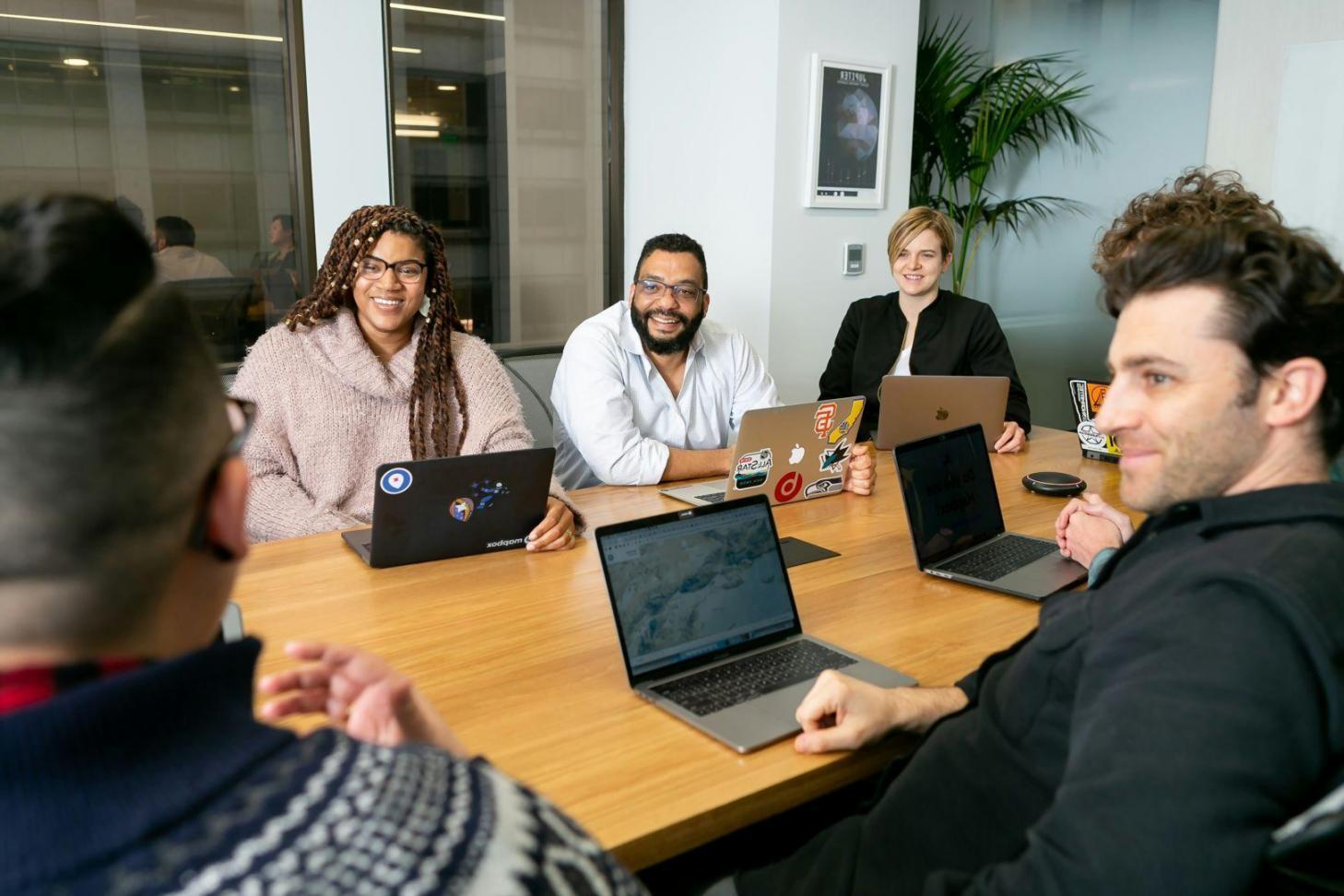 Strategic business planning session with multiple stakeholders reviewing integrated financial projections and business plans